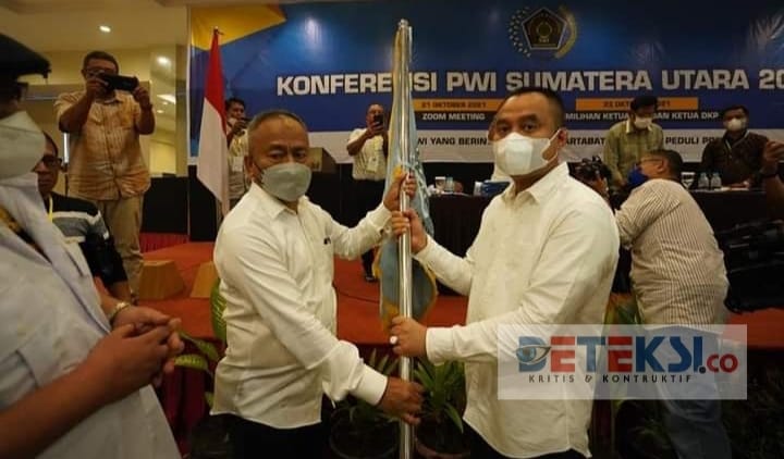 Ketua PWI Pusat Attal Depari menyerahkan bendera pataka kepada Ketua Terpilih PWI Sumut periode 2021-2026 H.Farianda Putra Sinik,SE.