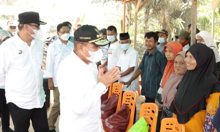 Gubernur Sumatera Utara Edy Rahmayadi didampingi Kadis Kehutanan Sumut Herianto, Kadis Perkebunan Lis Handayani Siregar, Sekda Madina Gozali Pulungan membagikan paket sembako kepada warga Desa Dalan Lidang dan Warga Desa Simpang Gambir di Lapangan Sepak Bola Desa Lidang Kecamatan Lingga Bayu Kabupaten Mandailingnatal, Rabu (27/4).