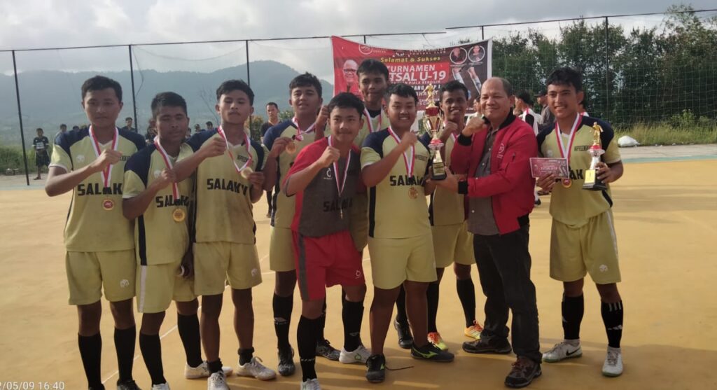 Ketua JGC, Pisser Agustinus Simamora diabadikan dengan Pemain Napasengkut FC yang menjuarai turnamen Futsal U-19 Junimart Girsang Cup di Kabupaten Pakpak Bharat, Senin (9/5/2022) di lapangan Sindeka. (DETEKSI.co/Parulian Phsp Nainggolan)
