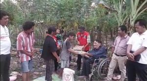 Ketua Relawan Junimart Girsang (RJG), Acun Hasiholan Sianturi, menyerahkan bantuan kepada keluarga Marihot Tambunan, Kamis (8/6/2023). (istimewa)