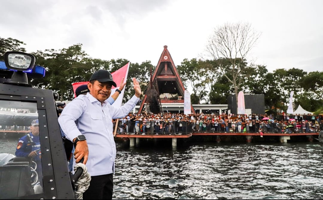 PJ Gubernur Sumatera Utara Hassanudin bersama Pangdam I/Bukit Barisan Mochammad Hasan menaiki boat saat melakukan parade pada penyelenggaraan Aquabike di Pelabuhan Balige, Kabupaten Toba, Sabtu (25/11). Para atlet dari berbagai negara juga turut pawai membawa bendera negara masing-masing.