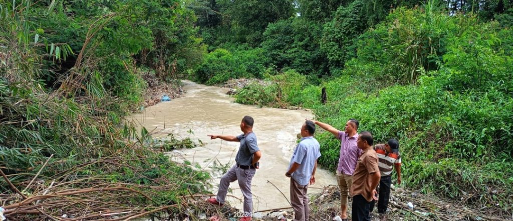 Ketua KNPI Dairi Alfriansyah Ujung meninjau titik longsor di aliran sungai Lae Nuaha. Jalur Sungai tertutup dan tanggul jebol sehingga arus alir berbelok membanjiri lahan warga. Jumat (24/11/2023) (DETEKSI.co/Parulian Phsp Nainggolan)