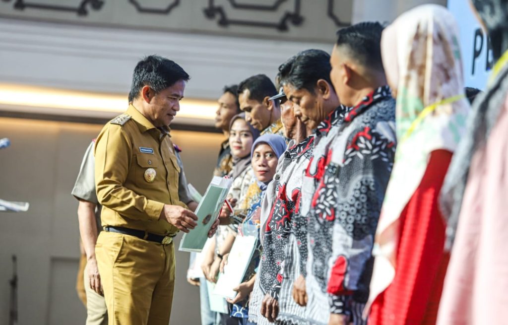 Penjabat (Pj) Gubernur Sumatera Utara (Sumut) Hassanudin menyerahkan sertifikat tanah secara simbolis pada masyarakat di Aula Raja Inal Siregar, Kantor Gubernur Sumut, Jalan Pangeran Diponegoro Nomor 30, Medan, Senin (4/12).