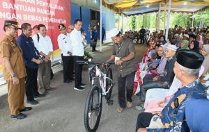 Penjabat (Pj) Gubernur Sumatera Utara (Sumut) Hassanudin mendampingi Presiden RI Joko Widodo (Jokowi) menyalurkan bantuan pangan cadangan beras pemerintah di GDT Hutalombang, Padanglawas, Jumat (15/3).
