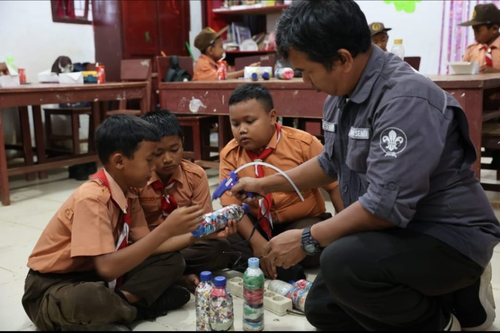 Fasilitator YPL Semut Merah mengajari siswa SDN 100712 Hapesong Lama membuat ecobrick hingga briket.(DETEKSI.co/Zatam)