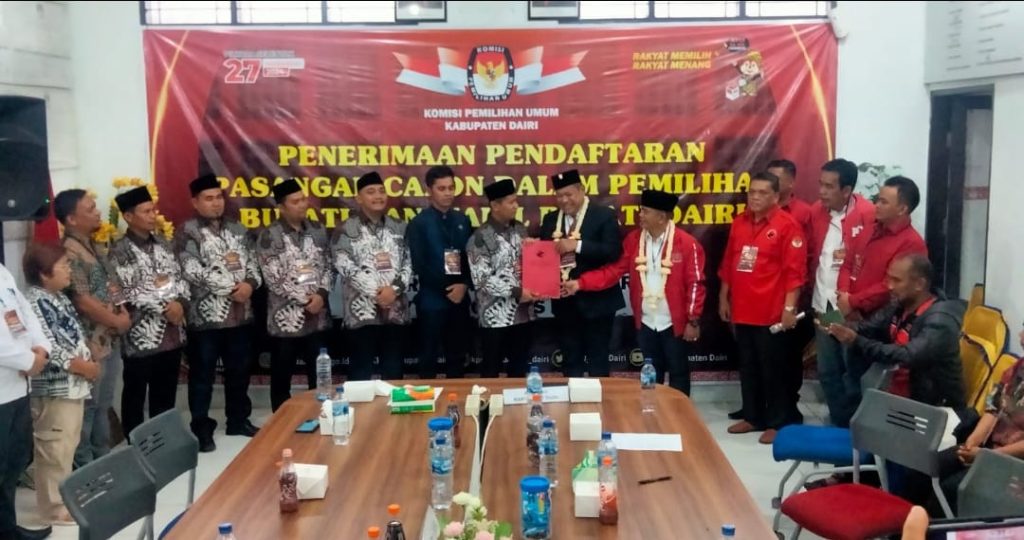 Bakal calon Bupati, Eddy Keleng Ate Berutu didampingi pasangannya Depriwanto Sitohang menyerahkan berkas pendaftaran diterima ketua KPU Dairi Aryanto Tinendung. Proses itu dilakukan bersama pengurus PDI Perjuangan Dairi, Kamis (29/8/2024) (DETEKSI.co/Parulian Phsp Nainggolan.