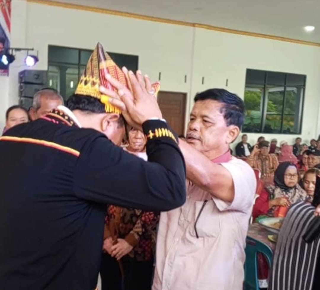 Kandidat Bupati Dairi nomor urut 4, Rimso Maruli Sinaga menerima bulang-bulang dari Marga Kudadiri, sebelum berangkat ke KPU Dairi untuk pengundian nomor urut. (Deteksi.co/istimewa)