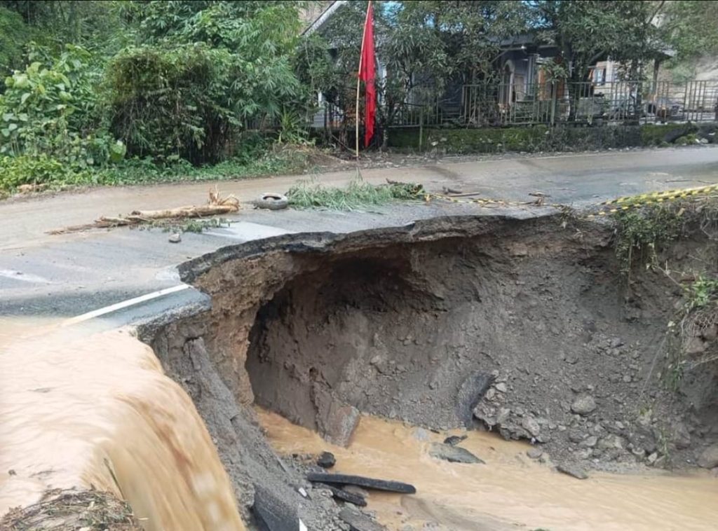 Badan jalan nasional lintasan Sidikalang–Kuta Cane di Desa Harapan Kecamatan Tanah Pinem Kabupaten Dairi Nyaris Putus, bagian yang tersisa berliang akibat tergerus aliran air bervolume besar, Kamis (17/10/2024). (istimewa)