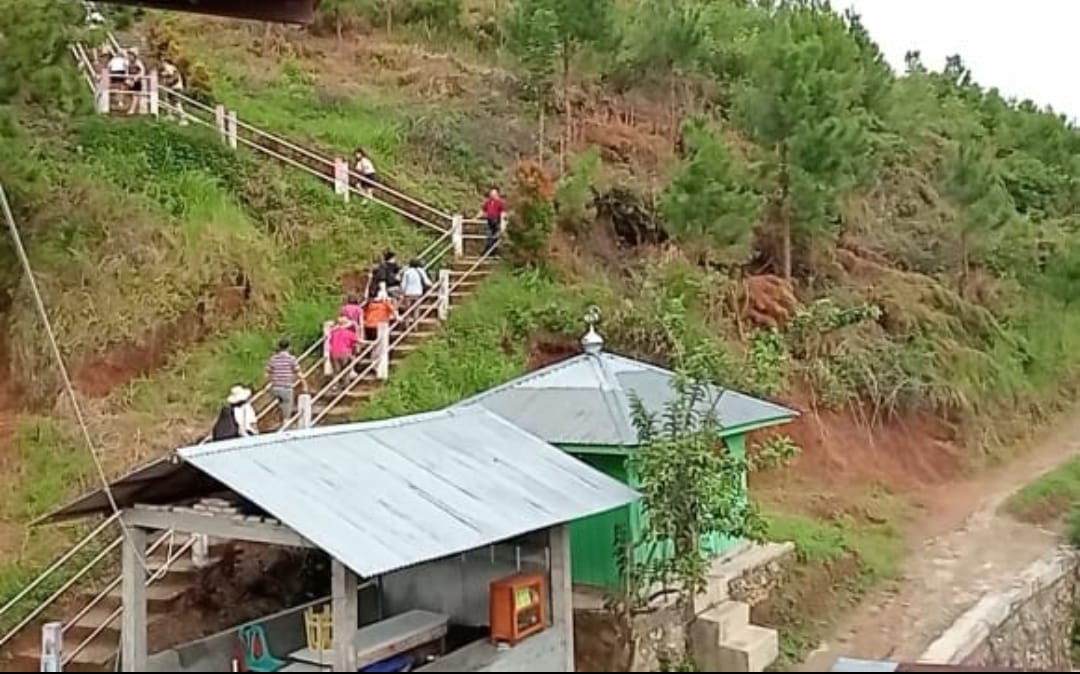 Rombongan wisatawan menaiki anak tangga untuk sampai di Bukit Holbung, Desa Hariarapohan, Kecamatan Harian, Kabupaten Samosir.