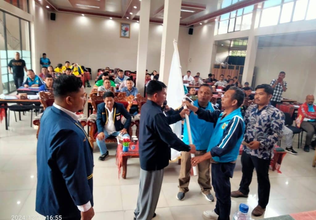 Mangaranap Manik menerima Pataka KONI dari pimpinan Sidang Musorkab Pandapotan Sianturi, setelah terpilih menjadi Ketua Umum KONI Dairi periode 2025-2029 pada Musorkab di Hotel Mutiara Sidikalang, Kamis (19/12/2024) (DETEKSI.co/Parulian Nainggolan)