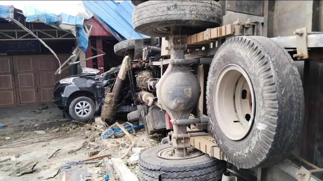 Truk terbalik di Jln SM. Raja Sumbul Kabupaten Dairi, mengakibatkan bangunan depan rumah warga rusak. Dalam gambar terlihat, kenderaan lain terlihat ringsek. Peristiwa itu juga menyebabkan ibu dan anak meninggal dunia. (Istimewa)