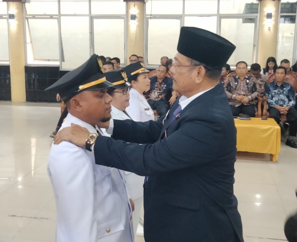 Bupati Dairi, Vickner Sinaga menyematkan tanda jabatan Camat pada pelantikan pejabat di Gedung Balai Budaya Sidikalang, Kamis (25/9/2024) (DETEKSI.co/Parulian Phsp Nainggolan)