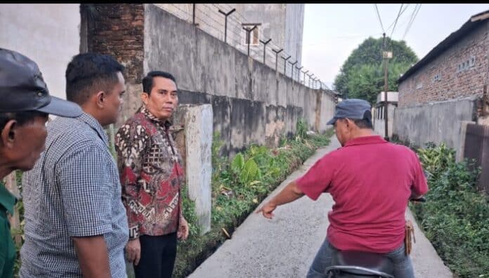 Anggota DPRD Kota Medan, Paul M.A. Simanjuntak meninjau jalan rusak di Jalan Tempuling Gang Ibu, Sabtu (21/2/2026).