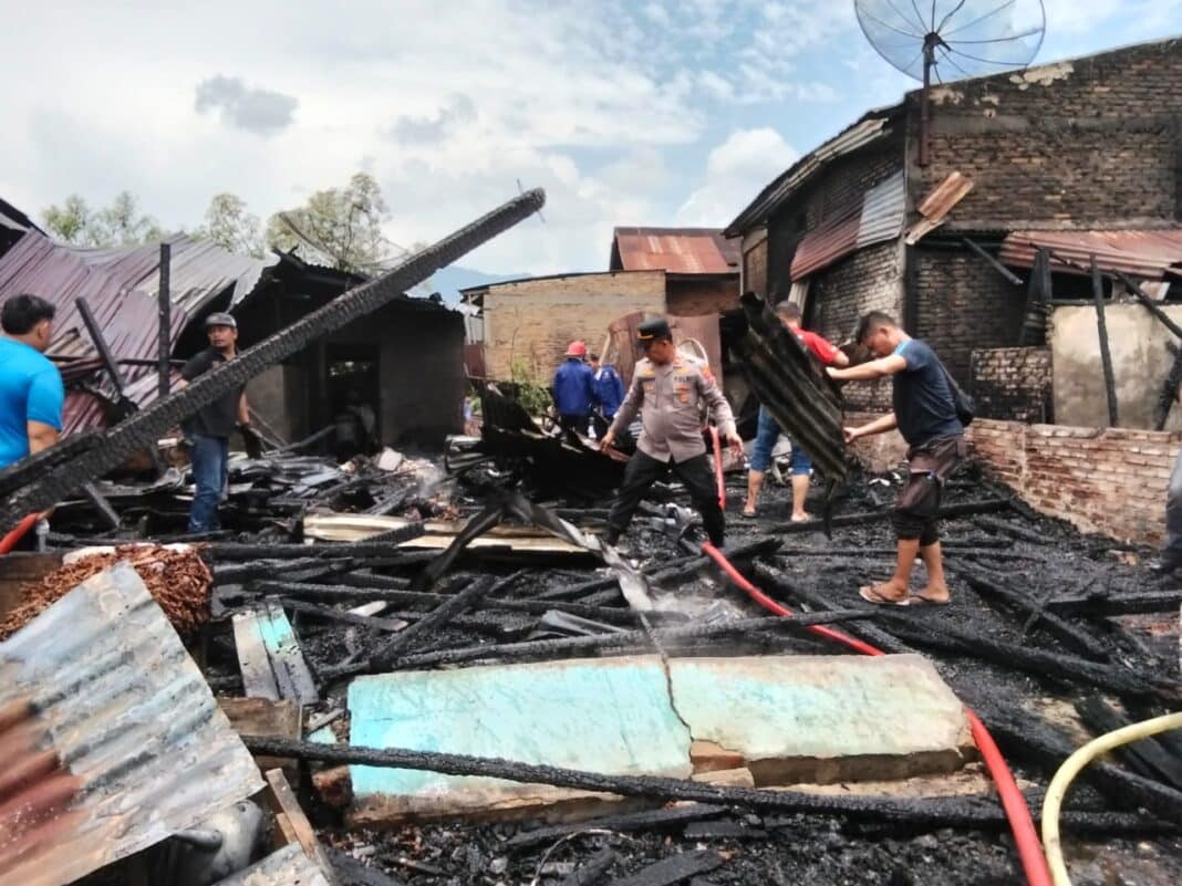 Petugas melakukan pendinginan pada puing bangunan yang ludes dilalap api di Kedeberek, Kecamatan Tigalingga, Kabupaten Dairi, Selasa (17/3/2026) siang. (Istimewa)