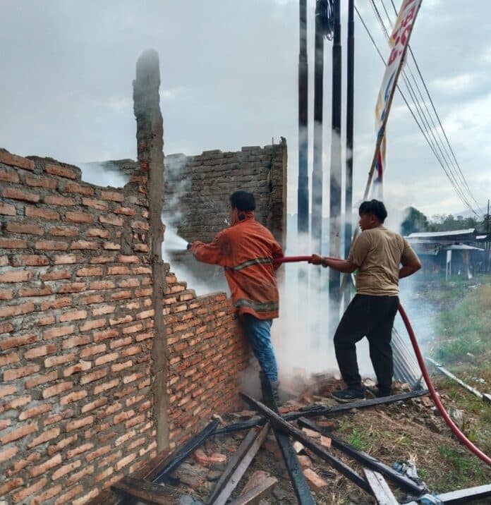 Petugas memadamkan api yang menghanguskan rumah semi permanan di Desa Tanah Pinem Kacamatan Tanah Pinem Kabupaten Dairi, Sabtu (14/3/2026) sore. (Istimewa)