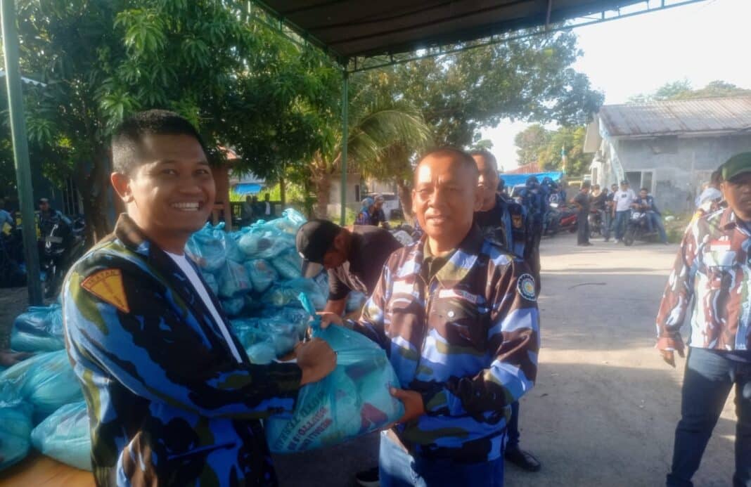 Ketua PAC IPK Medan Deli Wiwid Widodo didampingi Sekretaris Sahat Marpaung dan Bendahara Gunawan Damanik menyerahkan paket sembako kepada kader ranting dan sub ranting saat kegiatan pembagian ratusan sembako menyambut Idul Fitri 1447 H di Basecamp IPK Medan Deli, Kota Medan, Senin (16/3/2026).