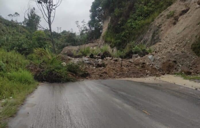 Badan jalan tertutup material longsor di Pangiringan, Desa Parbuluan V Kecamatan Parbuluan Kabupaten Dairi sebelum dinormalisasi BPBD Dairi. (Istimewa)