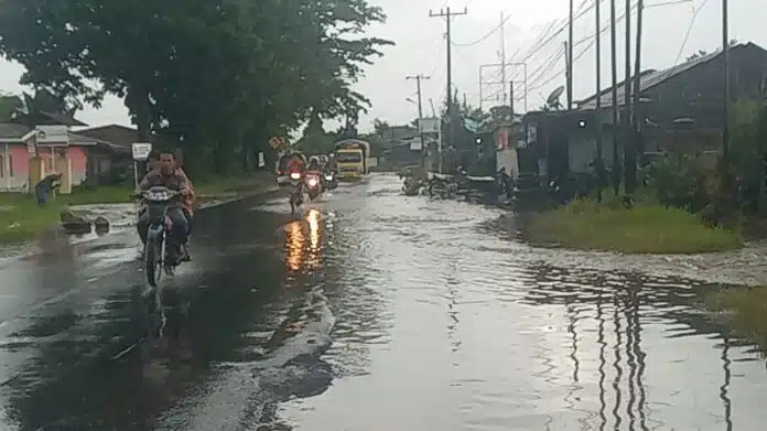 Diguyur hujan sebentar, badan jalan berubah mirip anak sungai dampak drainase yang tidak mampu menampung volume air. Petikan gambar merupakan kondisi jalan di depan Sopo Sahat Martua - Panji, Senin (20/4/2026) (DETEKSI.co/Parulian Nainggolan)