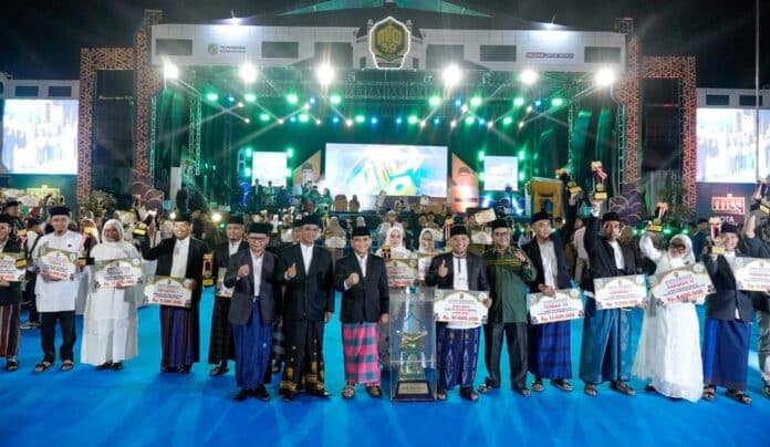 Asisten Pemerintahan dan Kesejahteraan Rakyat Setda Kota Medan, M. Sofyan, menyerahkan piala bergilir kepada Camat Medan Selayang, Muhammad Husnul Hafis, usai dinobatkan sebagai juara umum MTQ ke-59 tingkat Kota Medan 2026 di Jalan Gatot Subroto, Sabtu (18/4/2026) malam.