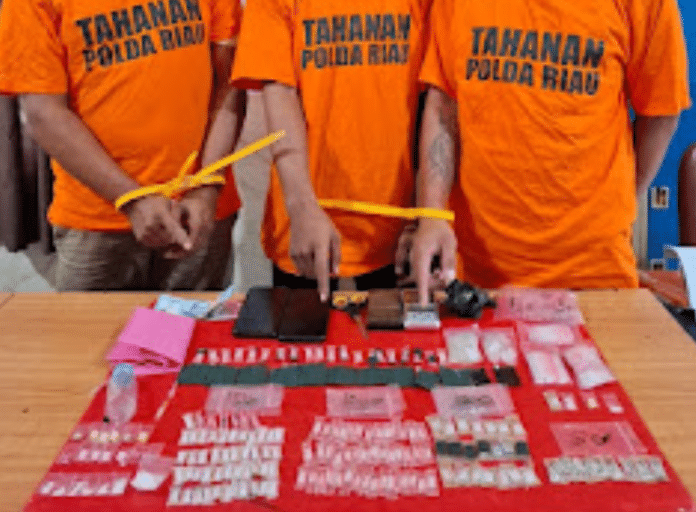 Tim Elang Kuantan Satres Narkoba Polres Kuantan Singingi memperlihatkan tiga tersangka beserta barang bukti narkotika jenis sabu dan pil ekstasi hasil penggerebekan di rumah kontrakan Desa Beringin Taluk, Kecamatan Kuantan Tengah, Senin (18/5/2026). Polisi menyita 164 paket sabu, 14 butir ekstasi, timbangan digital dan sejumlah alat pendukung peredaran narkoba.