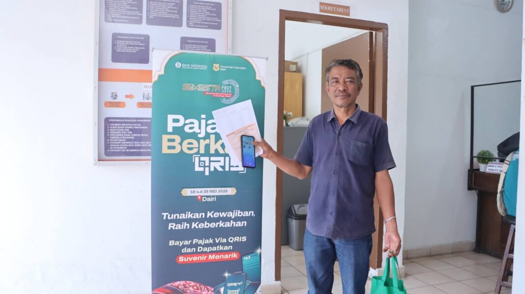 Salah seorang wajib pajak melakukan pembayaran non tunai dan mengapresiasi program Pajak Berkah QRIS tahun 2026, kolaborasi Pemkab Dairi dengan Kantor Perwakilan Bank Indonesia Sumatera Utara. (Istimewa)