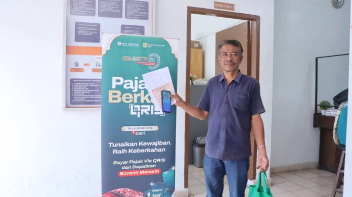 Salah seorang wajib pajak melakukan pembayaran non tunai dan mengapresiasi program Pajak Berkah QRIS tahun 2026, kolaborasi Pemkab Dairi dengan Kantor Perwakilan Bank Indonesia Sumatera Utara. (Istimewa)