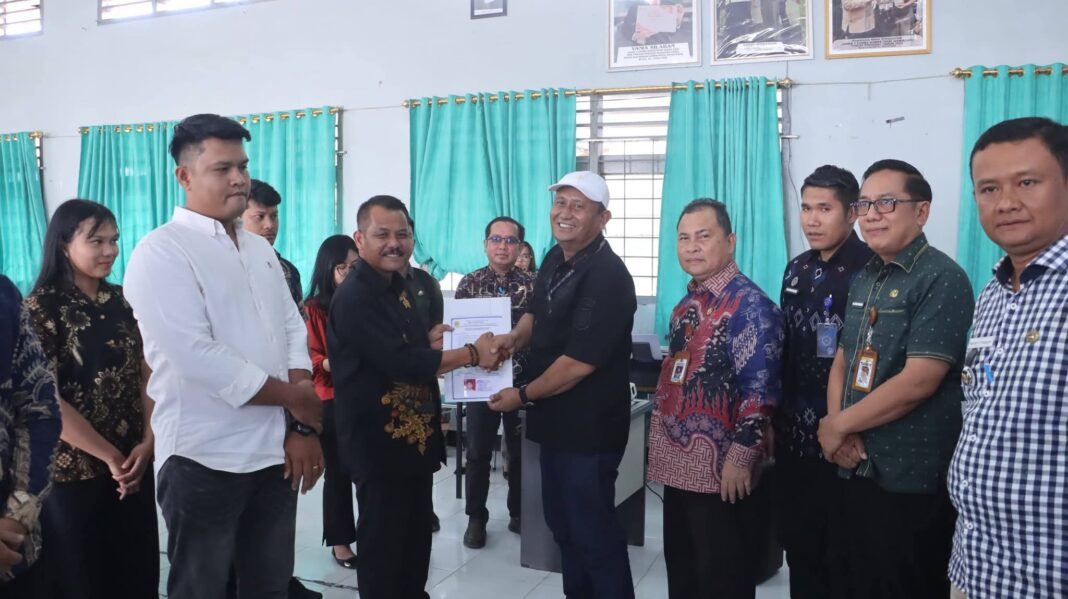 Ketua Satgas Percepatan Program MBG Dairi, Wahyu Daniel Sagala, menyerahkan Sertifikat Laik Higiene Sanitasi kepada 10 SPPG yang telah memenuhi syarat, di Aula di Aula SMK Negeri 1 Sidikalang, Jumat (22/5/2026). (Istimewa)