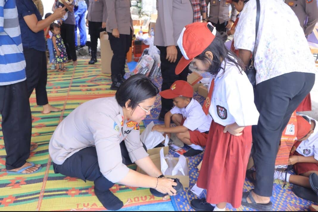 Kapolres Samosir AKBP Rina Sry Nirwana Tarigan bersama jajaran Polres Samosir menyerahkan bantuan sosial dan perlengkapan sekolah kepada warga serta siswa SD Negeri 13 Hasinggahan dalam kegiatan Bakti Sosial dan Bakti Kesehatan memperingati Hari Bhayangkara ke-80 Tahun 2026 di Kecamatan Sianjur Mulamula, Kabupaten Samosir, Selasa (23/6/2026).