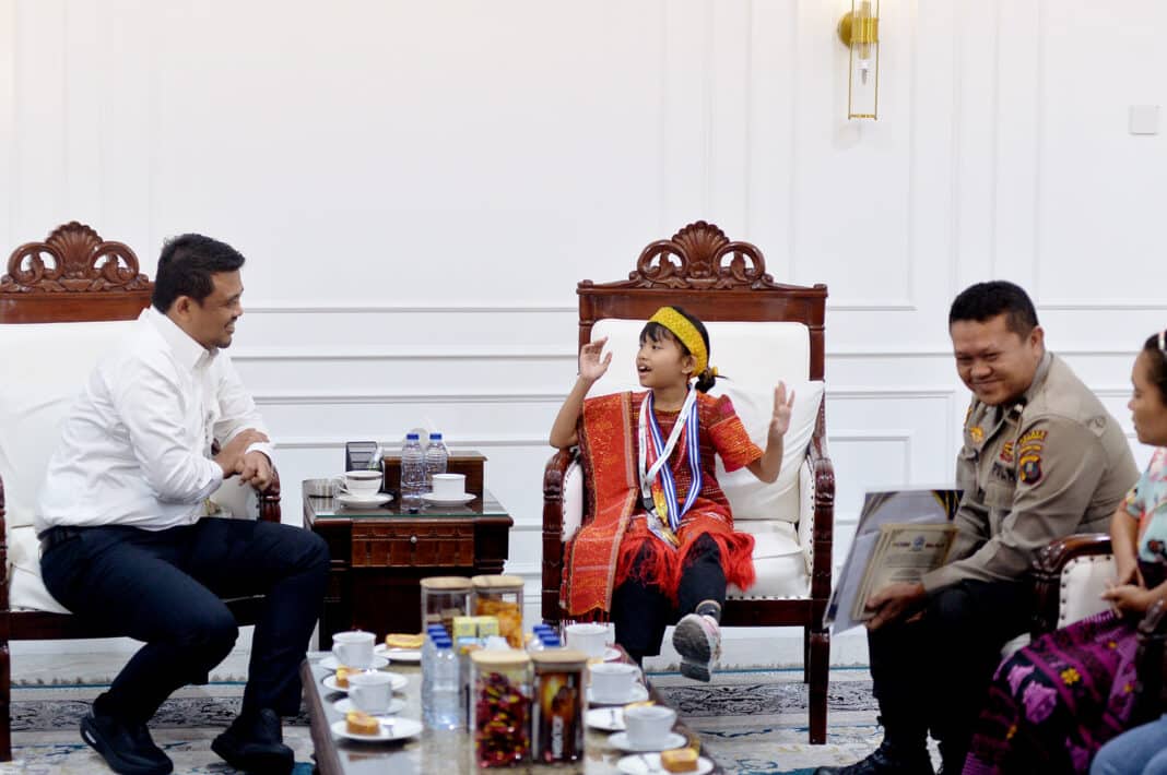 Gubernur Sumatera Utara Muhammad Bobby Afif Nasution menerima siswi peraih medali emas ASMC Global Round 2026, Caroline Cicilia Nababan, di Ruang Kerja Gubernur Sumut, Medan, sekaligus memberikan beasiswa, bantuan bimbingan belajar, dan tablet sebagai bentuk apresiasi atas prestasinya. (Foto Dok. Kominfo Sumut)