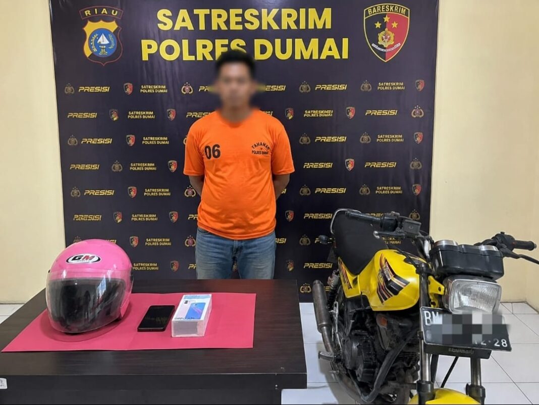 Petugas Satreskrim Polres Dumai menunjukkan tersangka berinisial JP beserta barang bukti hasil pengungkapan kasus dugaan pencurian dengan pemberatan di Kecamatan Dumai Selatan. Polisi mengamankan sepeda motor, telepon genggam, dan helm yang diduga merupakan hasil tindak pidana. (Foto Ilustrasi Dok. AI)