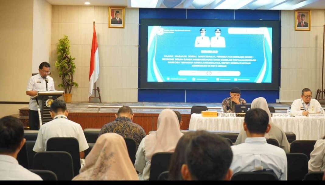 Staf Ahli Wali Kota Medan Adlan membacakan sambutan Wali Kota Rico Waas pada Seminar Hasil Kajian Masalah Sosial Masyarakat di Aula FISIP USU. Pemko Medan menegaskan penanganan narkoba dan kriminalitas harus dilakukan melalui pendekatan terpadu yang mencakup penguatan ekonomi, kesehatan sosial, dan ketahanan keluarga.