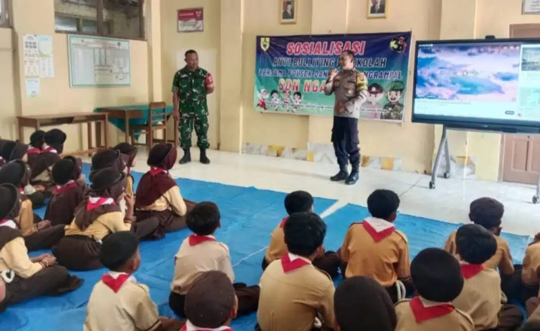 Babinsa Desa Ngarum Serda Sutrisno bersama Bhabinkamtibmas Desa Ngarum Aipda Ambar Woko memberikan sosialisasi bahaya bullying kepada 75 siswa SDN Ngarum 1, Kecamatan Ngrampal, Kabupaten Sragen. (Foto Dok. Agus Kemplu)