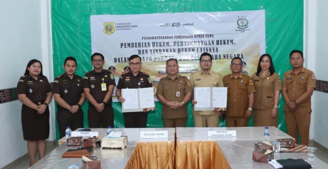 Kepala Bapenda Dairi, Robot Simanullang dan Kajari Dairi, Bima Yudha Asmara memperlihatkan naskah kerjasama setelah ditandatangani. (Istimewa)