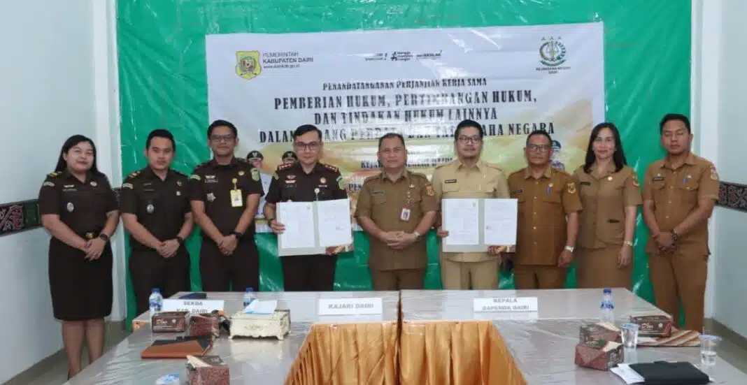Kepala Bapenda Dairi, Robot Simanullang dan Kajari Dairi, Bima Yudha Asmara memperlihatkan naskah kerjasama setelah ditandatangani. (Istimewa)