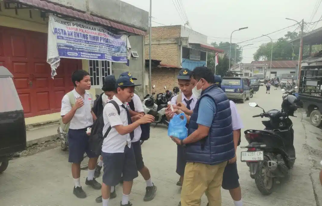Sejumlah wartawan bersama Efendy Naibaho dan Sekretaris PWI Samosir Hotdon Naibaho membagikan masker gratis kepada para pelajar di Pangururan, Kabupaten Samosir, Kamis (15/10/2026), sebagai bentuk kepedulian terhadap kesehatan anak-anak di tengah kabut asap.