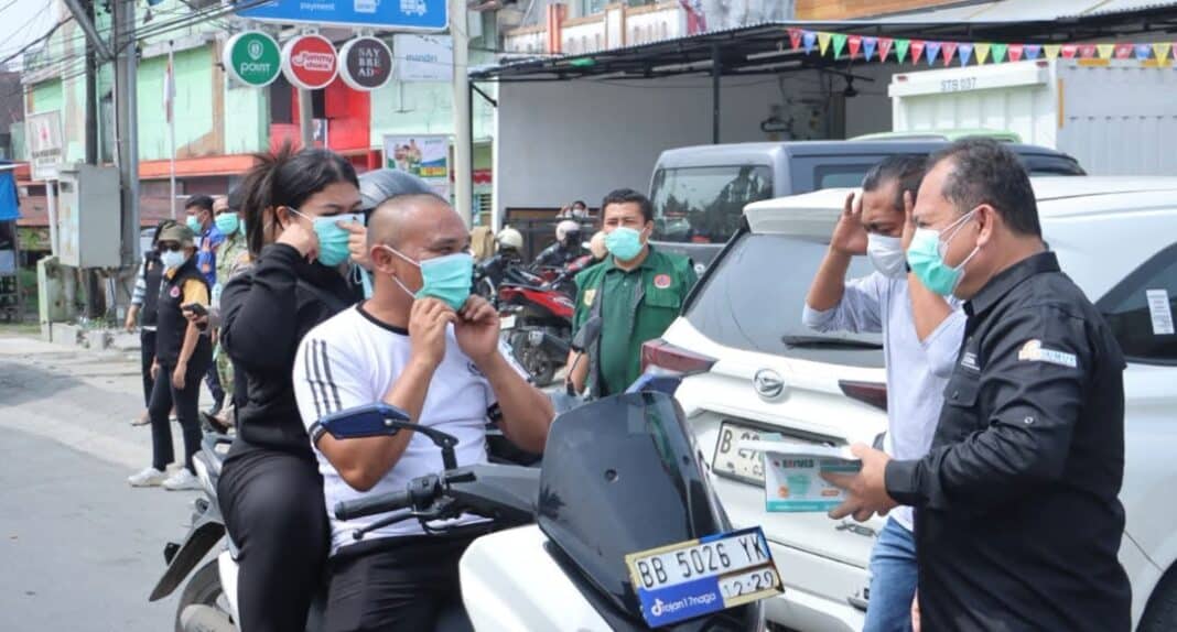 Pemkab dan Forkopimda Dairi membagikan masker kepada warga yang berlalulintas di depan Kantor Bupati Dairi, Jumat (16/10/2026)